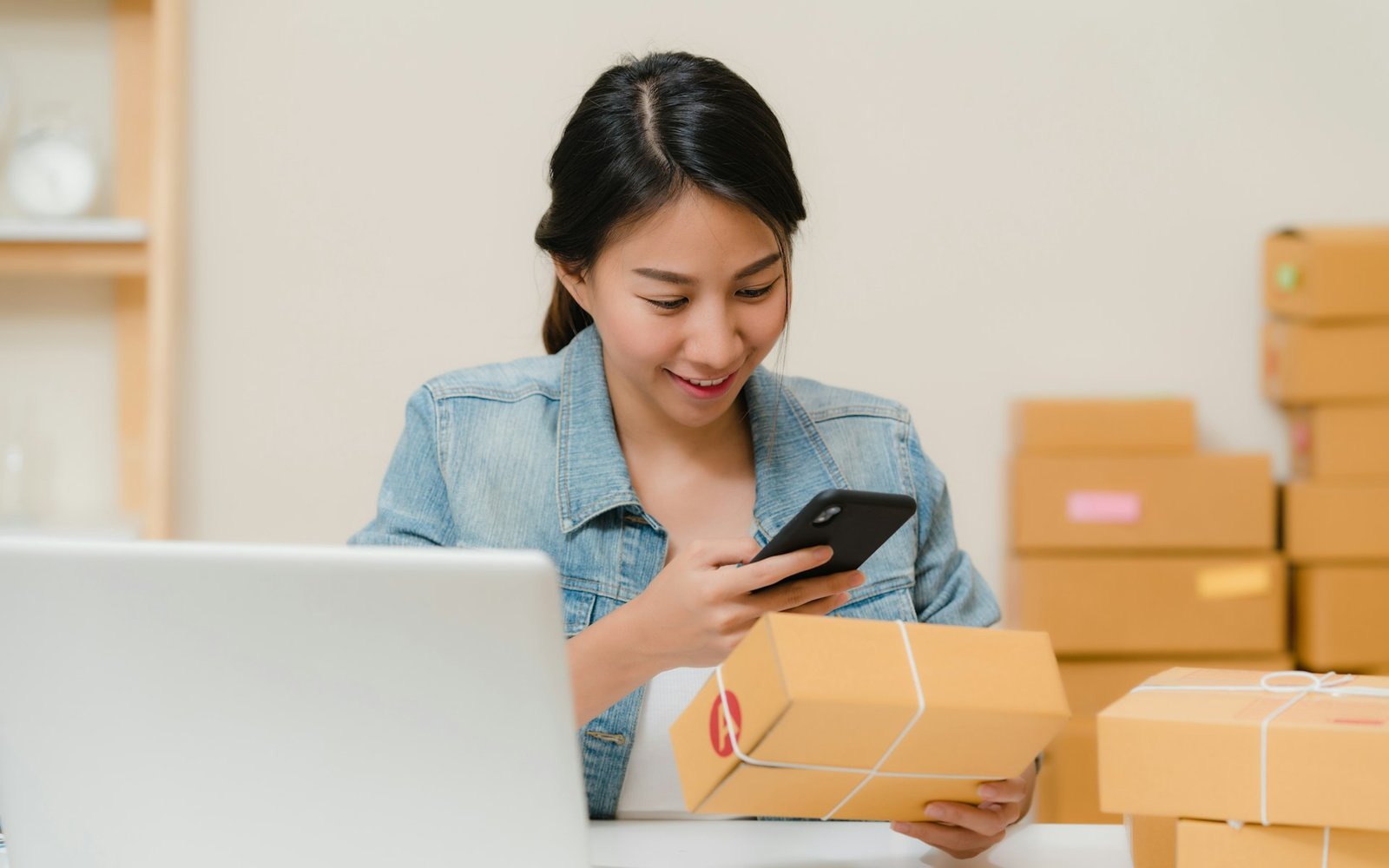 Mujer preparando pedidos entre cajas