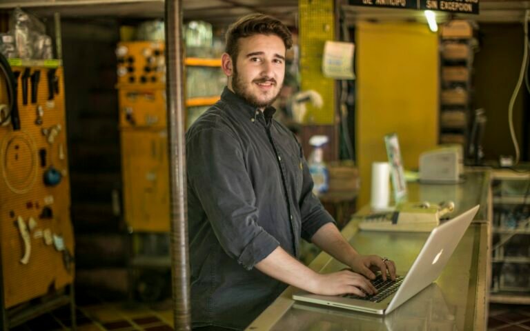Dueño de un comercio con el portátil en el mostrador