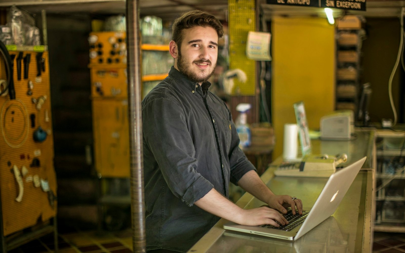 Dueño de un comercio con el portátil en el mostrador